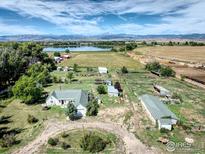 Aerial view of a house and expansive property with a lake in the background at 14619 N 115Th St, Longmont, CO 80504