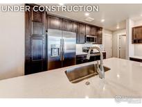 Modern kitchen with stainless steel appliances and quartz countertops at 265 High Point Dr # 304, Longmont, CO 80504