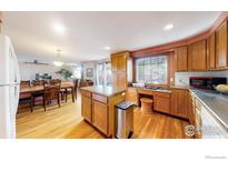 Eat-in kitchen with island and views into dining area at 1233 Sunset St, Longmont, CO 80501