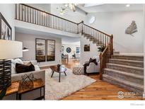 Spacious living room with hardwood floors, a cozy seating area, and a view to the dining area at 3123 Concord Way, Longmont, CO 80503