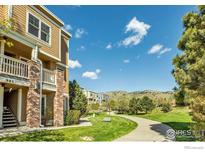 Tan multi-unit building with brick accents, walkway, and mountain views at 985 Laramie Blvd # C, Boulder, CO 80304