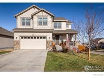 Two-story house with beige siding, stone accents, and a two-car garage at 810 Ranchhand Dr, Berthoud, CO 80513