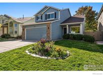 Two-story house with gray siding, brick accents, and landscaped yard at 1411 Vinca Pl, Superior, CO 80027