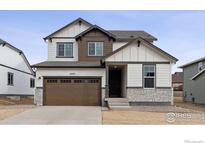 Two-story house with a brown double garage door and stone accents at 16870 Mckay Dr, Mead, CO 80542