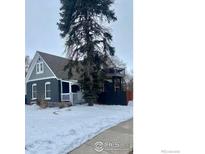 Charming two-story home with a deck and snowy front yard at 203 S 3Rd Ave, Brighton, CO 80601