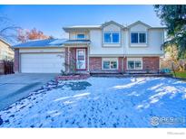 Two-story house with attached garage, landscaping, and snowy lawn at 2154 Stuart St, Longmont, CO 80501