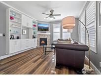 Spacious living room features a fireplace, built-in shelving, and hardwood floors at 12871 King St, Broomfield, CO 80020