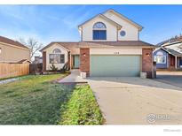 Brick two-story house with attached garage and landscaped yard at 1749 Foster Dr, Longmont, CO 80501