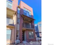 Three-story brick townhouse with balcony and modern design at 2371 Stonecrop Way, Superior, CO 80027