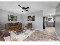 Open living room with a view into the kitchen and modern flooring at 2495 Fairplay St, Aurora, CO 80011