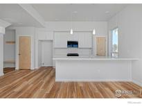 Modern kitchen featuring white cabinets, island, and stainless steel appliances at 733 Kubat Ln # A, Longmont, CO 80503