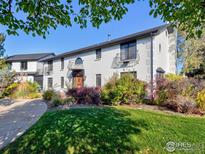 Charming two-story home with white brick exterior, decorative balconies, and landscaped yard at 1490 Saint Andrews Dr, Broomfield, CO 80020