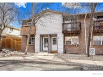 Front exterior of a two-story condo building with balconies and resident parking at 2049 Estes Ln # 4, Longmont, CO 80501