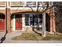 Charming townhome exterior with a red door, stone accents, and a small patio area at 4800 Osage Dr # 1, Boulder, CO 80303