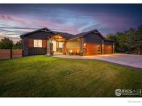 Modern two-story home with a three-car garage, landscaped yard, and a fire pit at 740 W County Road 10 E, Berthoud, CO 80513