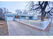 Charming blue house with white picket fence and landscaped yard at 202 9Th Ave, Longmont, CO 80501