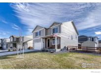 Two-story house with gray siding, attached garage, and landscaped yard at 2262 Monte Vista St, Fort Lupton, CO 80621