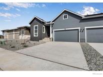 Gray two-story home with attached garage and landscaping at 1784 Mount Meeker Ave, Berthoud, CO 80513