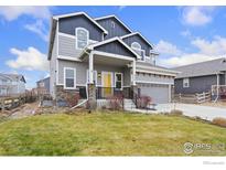 Two-story house with gray siding, stone accents, and a landscaped lawn at 357 Canyonlands St, Berthoud, CO 80513