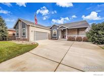 Brick house with gray accents, attached garage, and landscaped lawn at 9042 Eldorado Ave, Frederick, CO 80504