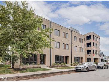 Three-story building with multiple units, landscaping, and street parking at 319 E 16Th St # 207, Indianapolis, IN 46202