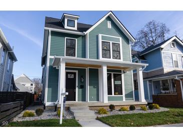 Two-story craftsman home with a teal exterior, white trim, and a welcoming front porch at 2133 N Talbott St, Indianapolis, IN 46202