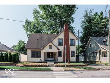 Full exterior view of a charming two-story house with a brick chimney and well-maintained lawn at 819 E 49Th St, Indianapolis, IN 46205