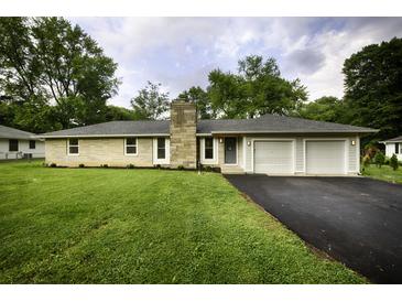Ranch home with stone facade, attached two-car garage, and landscaped lawn at 8827 El Rico Dr, Indianapolis, IN 46240