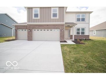 Two-story home with brick and siding exterior, three-car garage, and a landscaped yard at 1305 Bert Rd, Danville, IN 46122