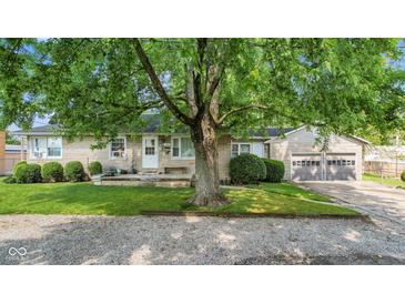 Stone house with a large tree and two-car garage at 11445 N School St, Fishers, IN 46038