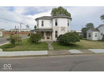 Two-story house with a wrap-around porch and mature landscaping at 401 S Walnut St, Edinburgh, IN 46124