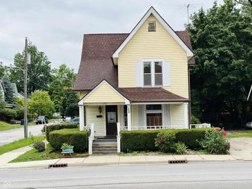 Yellow house with brown roof and landscaping at 202 N State St, Greenfield, IN 46140