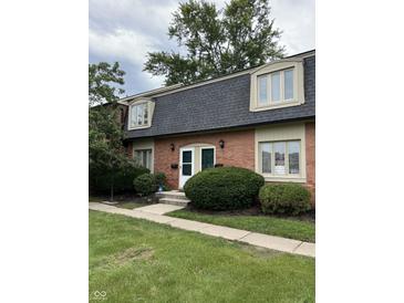 Brick townhouse with a gray roof and landscaping at 1159 Canterbury S Sq, Indianapolis, IN 46260