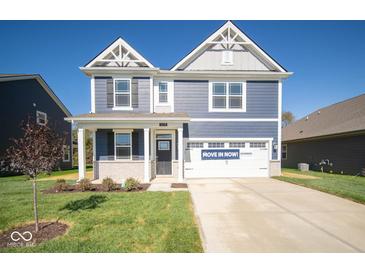 Two-story home with a blue exterior, two-car garage and landscaping at 1678 Orchard Dr, Fortville, IN 46040