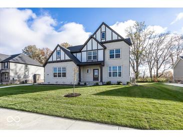 Two-story house with white brick and a gabled roof, showcasing a manicured lawn at 9317 Coopers Ln, McCordsville, IN 46055
