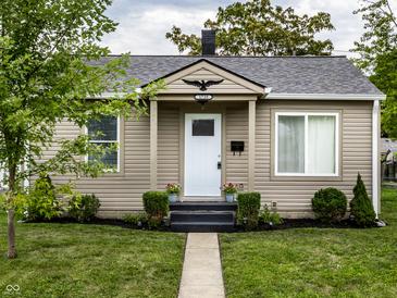 Tan house with white door, landscaping, and walkway at 1739 Asbury St, Indianapolis, IN 46203