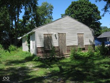 Small house needing repairs, boarded windows, brick base at 3318 S Rybolt Ave, Indianapolis, IN 46221