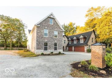 Brick house with a three-car garage and landscaping at 437 W 86Th St, Indianapolis, IN 46260