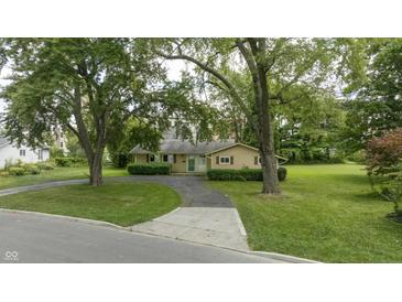 Ranch style home with green lawn and mature trees at 449 Emerson Rd, Carmel, IN 46032