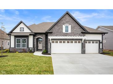 Two-story home with stone accents and a three-car garage at 15827 Scarteen Rd, Fishers, IN 46040