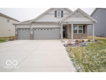 Two-story home with gray siding, brick accents, and a three-car garage at 180 Velvet Hat Rd, Danville, IN 46122