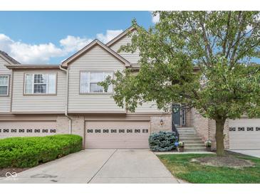 Tan two-story home with a two-car garage and manicured lawn at 10190 Winslow Way, Fishers, IN 46037