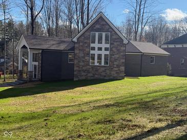 Stunning modern home with brick and stone exterior, large windows, and a spacious lawn at 3380 N Pine Song Dr, Martinsville, IN 46151