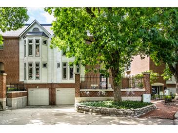 Brick townhouse with a two-car garage and landscaping at 571 Lockerbie S Cir, Indianapolis, IN 46202