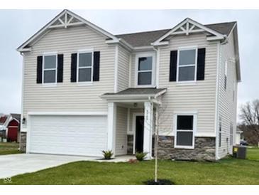 Two-story house with beige vinyl siding, stone accents, and a two-car garage at 3568 Berkdale Dr, Columbus, IN 47203