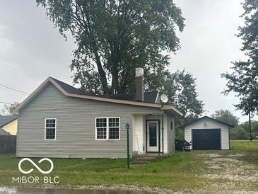 Ranch style home with gray siding and detached garage at 108 N Summit St, Summitville, IN 46070