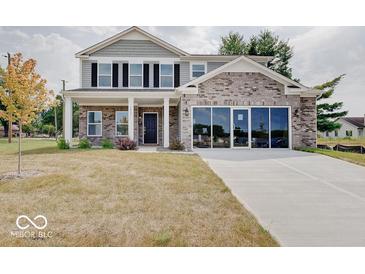 Two story brick home with gray siding and three car garage at 3923 Windstar Way, Columbus, IN 47203