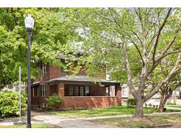 Brick house with front porch, surrounded by trees at 3860 N Delaware St, Indianapolis, IN 46205