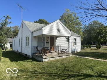White house with a covered porch and a manicured lawn at 616 W 38Th St, Anderson, IN 46013