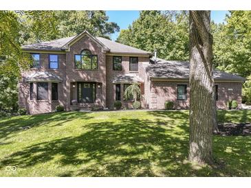 Brick two story home with a large front yard and mature trees at 5826 Winding Way Ln, Indianapolis, IN 46220